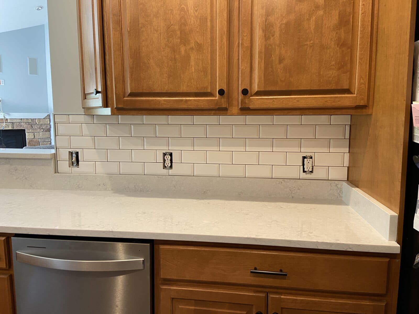 Kitchen counter and dishwasher under subway tile backsplash